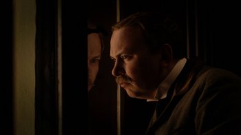 Movie still from “The Illusionist” (2006), directed by Neil Burger – A man in a suit and tie looking into a mirror; Close Up shot, Low angle