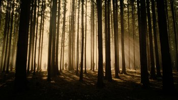 Movie still from “The Illusionist” (2006), directed by Neil Burger – A group of people standing in the middle of a forest; Extreme Wide shot, Low angle