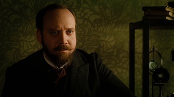 Movie still from “The Illusionist” (2006), directed by Neil Burger – A man with a goatee and beard wearing a suit and tie; Close Up shot, Low angle