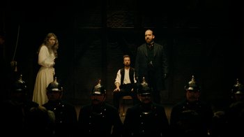 Movie still from “The Illusionist” (2006), directed by Neil Burger – A group of men standing next to each other in a room; Wide shot, High angle