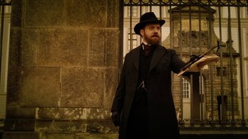 Movie still from “The Illusionist” (2006), directed by Neil Burger – A man in a black coat and a black hat; Medium shot, Low angle