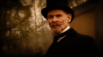 Movie still from “The Illusionist” (2006), directed by Neil Burger – An old man with a beard wearing a top hat; Close Up shot, Low angle