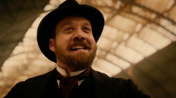 Movie still from “The Illusionist” (2006), directed by Neil Burger – A man with a beard wearing a suit and a hat; Close Up shot, Low angle