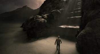 Movie still from “The Imaginarium of Doctor Parnassus” (2009), directed by Terry Gilliam – A man is walking through a cave in the mountains; Extreme Wide shot, High angle