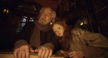 Movie still from “The Imaginarium of Doctor Parnassus” (2009), directed by Terry Gilliam – An old man and a young girl looking down at a piece of paper; Medium shot, Low angle