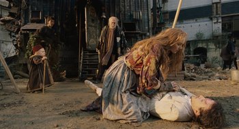 Movie still from “The Imaginarium of Doctor Parnassus” (2009), directed by Terry Gilliam – An old man and a young woman are on the ground; Wide shot, High angle