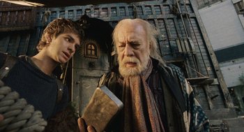 Movie still from “The Imaginarium of Doctor Parnassus” (2009), directed by Terry Gilliam – A man holding a book in front of another man; Close Up shot, Low angle