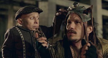 Movie still from “The Imaginarium of Doctor Parnassus” (2009), directed by Terry Gilliam – Two men in medieval garb one of which is holding a whip; Close Up shot, Over the shoulder angle