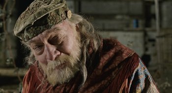 Movie still from “The Imaginarium of Doctor Parnassus” (2009), directed by Terry Gilliam – An old man with long white hair wearing a hat; Close Up shot, Low angle