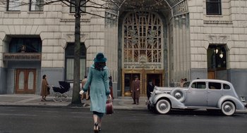 Movie still from “The Imaginarium of Doctor Parnassus” (2009), directed by Terry Gilliam – A woman in a blue coat and hat walking down the street; Extreme Wide shot, Low angle