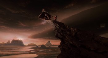 Movie still from “The Imaginarium of Doctor Parnassus” (2009), directed by Terry Gilliam – A person sitting on top of a cliff; Extreme Wide shot, High angle