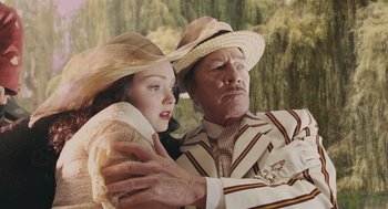 Movie still from “The Imaginarium of Doctor Parnassus” (2009), directed by Terry Gilliam – A man and a woman wearing hats and holding each other; Medium shot, Low angle