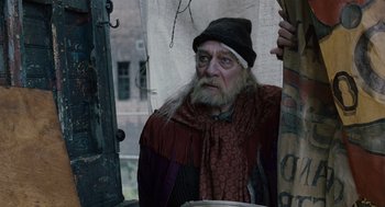 Movie still from “The Imaginarium of Doctor Parnassus” (2009), directed by Terry Gilliam – An old man with long white hair and a long beard; Medium shot, Over the shoulder angle