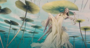 Movie still from “The Imaginarium of Doctor Parnassus” (2009), directed by Terry Gilliam – A woman in a yellow dress floating in a body of water; Wide shot, Overhead angle