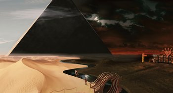 Movie still from “The Imaginarium of Doctor Parnassus” (2009), directed by Terry Gilliam – An image of a person sitting on a bench in the desert; Extreme Wide shot, High angle