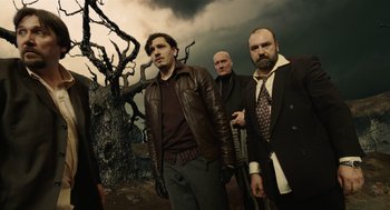 Movie still from “The Imaginarium of Doctor Parnassus” (2009), directed by Terry Gilliam – A group of men standing next to each other in front of a tree; Medium shot, Low angle