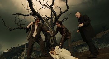 Movie still from “The Imaginarium of Doctor Parnassus” (2009), directed by Terry Gilliam – A group of men standing around a dead body; Wide shot, Low angle