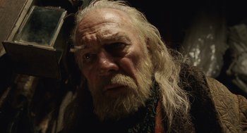 Movie still from “The Imaginarium of Doctor Parnassus” (2009), directed by Terry Gilliam – An old man with long white hair and a beard; Close Up shot, Low angle