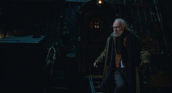 Movie still from “The Imaginarium of Doctor Parnassus” (2009), directed by Terry Gilliam – An old man walking down a street at night; Wide shot, Low angle