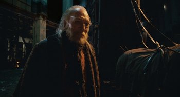 Movie still from “The Imaginarium of Doctor Parnassus” (2009), directed by Terry Gilliam – An old man with long white hair and a beard; Close Up shot, Low angle