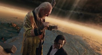 Movie still from “The Imaginarium of Doctor Parnassus” (2009), directed by Terry Gilliam – An old man and a young man are standing in front of a sky; Medium shot, Over the shoulder angle