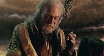 Movie still from “The Imaginarium of Doctor Parnassus” (2009), directed by Terry Gilliam – An old man with a long white beard holding a cell phone; Close Up shot, Over the shoulder angle