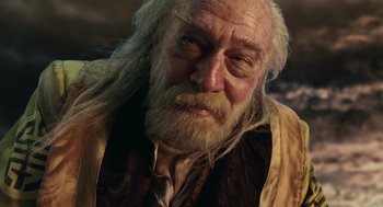 Movie still from “The Imaginarium of Doctor Parnassus” (2009), directed by Terry Gilliam – An old man with long white hair and a beard; Close Up shot, Low angle