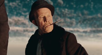 Movie still from “The Imaginarium of Doctor Parnassus” (2009), directed by Terry Gilliam – An older man wearing a hat and smoking a cigarette; Close Up shot, Low angle