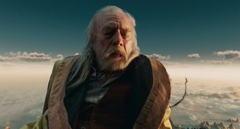 Movie still from “The Imaginarium of Doctor Parnassus” (2009), directed by Terry Gilliam – An old man with long white hair and a beard; Medium shot, Low angle