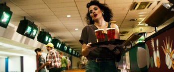 Movie still from “The Infiltrator” (2016), directed by Brad Furman – A woman holding a tray with two beers on top of it; Medium shot, Low angle