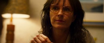 Movie still from “The Infiltrator” (2016), directed by Brad Furman – A person wearing glasses with their hands clasped; Close Up shot, Over the shoulder angle