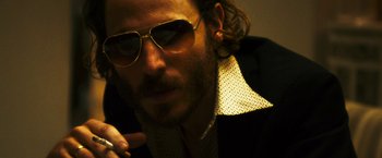 Movie still from “The Infiltrator” (2016), directed by Brad Furman – A person wearing a suit and sunglasses; Close Up shot, Low angle
