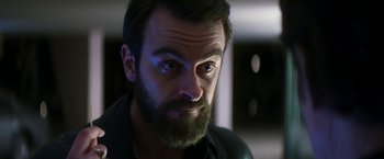 Movie still from “The Infiltrator” (2016), directed by Brad Furman – A person with a beard looking at the camera; Close Up shot, Low angle