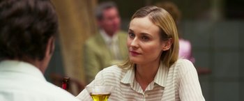 Movie still from “The Infiltrator” (2016), directed by Brad Furman – A woman sitting at a table with a glass of wine; Close Up shot, Over the shoulder angle