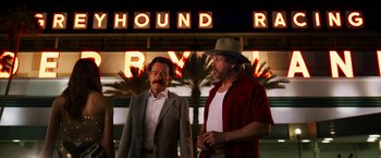 Movie still from “The Infiltrator” (2016), directed by Brad Furman – A couple of men standing next to each other in front of a building; Medium shot, Low angle