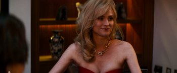 Movie still from “The Infiltrator” (2016), directed by Brad Furman – A woman in a strapless red dress with a gold chain around her neck; Close Up shot, Over the shoulder angle