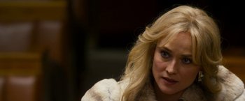 Movie still from “The Infiltrator” (2016), directed by Brad Furman – A woman with blonde hair wearing a white fur coat; Close Up shot, Over the shoulder angle