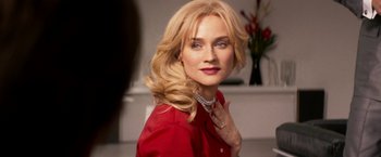 Movie still from “The Infiltrator” (2016), directed by Brad Furman – A woman in a red shirt is posing for a picture; Close Up shot, Over the shoulder angle