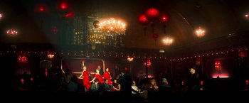 Movie still from “The Infiltrator” (2016), directed by Brad Furman – A group of people sitting in a room with lights in the background; Extreme Wide shot, High angle