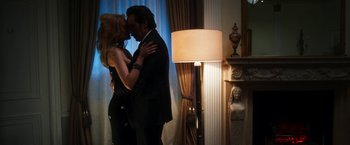 Movie still from “The Infiltrator” (2016), directed by Brad Furman – A man and a woman kissing in front of a lamp; Medium shot, Low angle