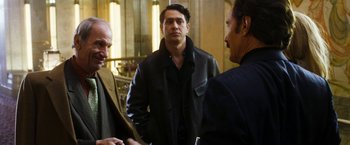 Movie still from “The Infiltrator” (2016), directed by Brad Furman – A group of men standing next to each other in a room; Medium shot, Over the shoulder angle