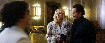 Movie still from “The Infiltrator” (2016), directed by Brad Furman – A man and a woman standing next to each other in front of lights; Medium shot, Over the shoulder angle