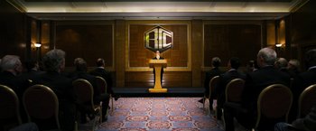 Movie still from “The Infiltrator” (2016), directed by Brad Furman – A man standing at a lectern in front of three other men; Extreme Wide shot, Over the shoulder angle