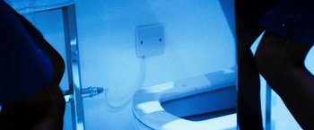 Movie still from “The Infiltrator” (2016), directed by Brad Furman – A white toilet bowl with the lid open and the seat up; Extreme Close Up shot, Overhead angle