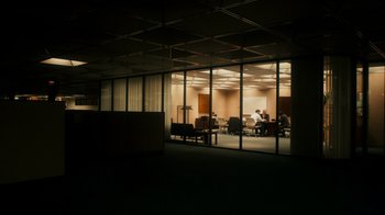 Movie still from “The Informant!” (2009), directed by Steven Soderbergh – An empty room with a group of people sitting at a table in it; Extreme Wide shot, Low angle