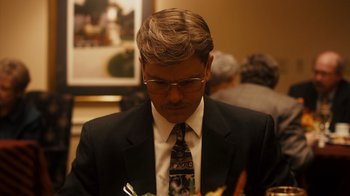 Movie still from “The Informant!” (2009), directed by Steven Soderbergh – A man in a suit and tie looking down; Close Up shot, High angle