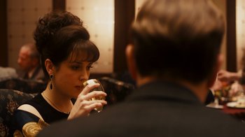 Movie still from “The Informant!” (2009), directed by Steven Soderbergh – A woman holding a drink in her hand while looking in the mirror; Close Up shot, Over the shoulder angle