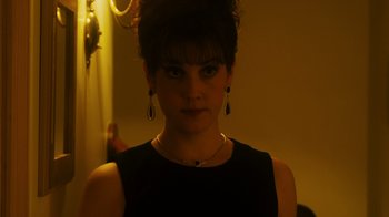 Movie still from “The Informant!” (2009), directed by Steven Soderbergh – A young woman wearing a black dress and a black necklace; Close Up shot, Over the shoulder angle