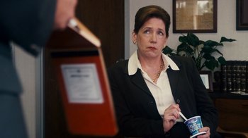Movie still from “The Informant!” (2009), directed by Steven Soderbergh – A woman in a black jacket and white shirt holding a pen; Medium shot, Over the shoulder angle