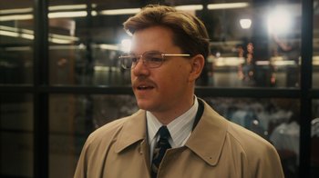 Movie still from “The Informant!” (2009), directed by Steven Soderbergh – A man in a tan coat and tie; Close Up shot, Over the shoulder angle